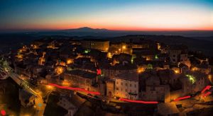 Un village médiéval avec une architecture historique, illuminé par les lumières chaudes du coucher de soleil.