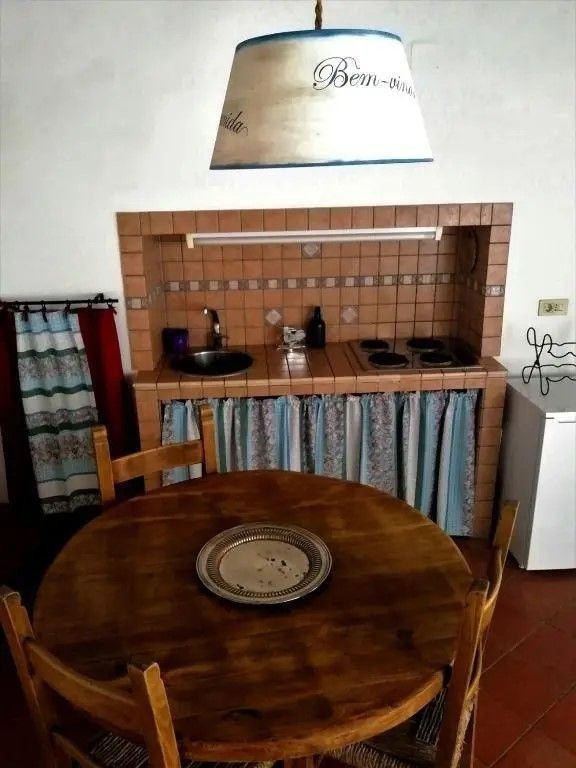 Un coin cuisine simple et fonctionnel dans un studio situé dans un village, idéal pour un séjour intime.