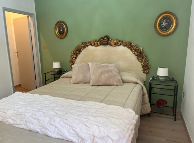 Camera semplice con tonalità verdi e elementi di arredo tradizionali, adatta per momenti di relax.