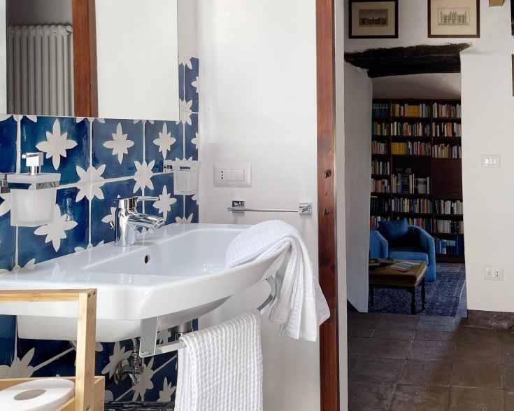 Innenansicht eines Badezimmers mit blauen und weißen Fliesen, schlichtem und hellem Design, das eine gemütliche Atmosphäre schafft.