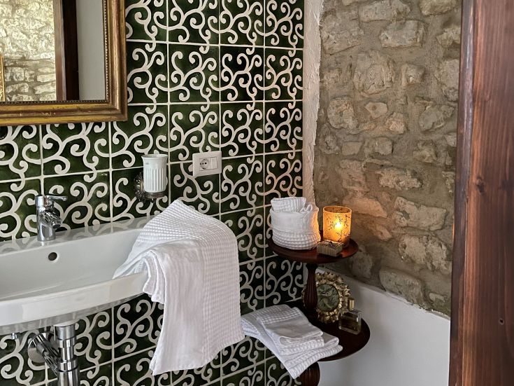 Einladendes Bad mit grünen Fliesen und Holzelementen, das eine warme und einladende Atmosphäre schafft.