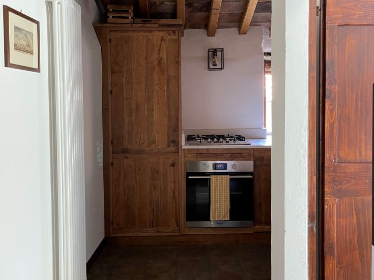 Einfache Holzküche mit Herd und Ofen. Ein ruhiger Ort, um gemeinsame Momente zu genießen.