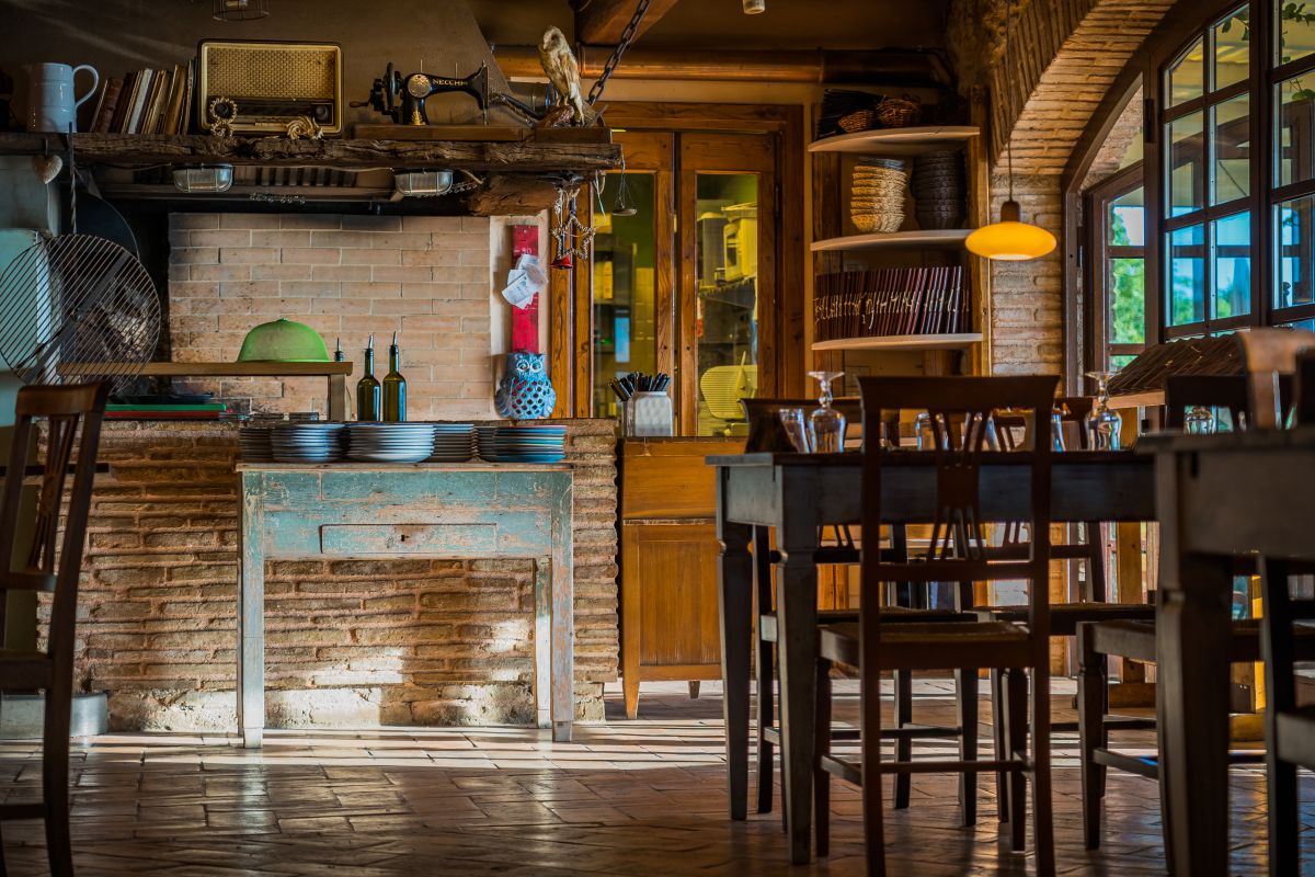 Un accogliente ristorante arredato con elementi rustici, immerso in un contesto di olivi e tradizione.