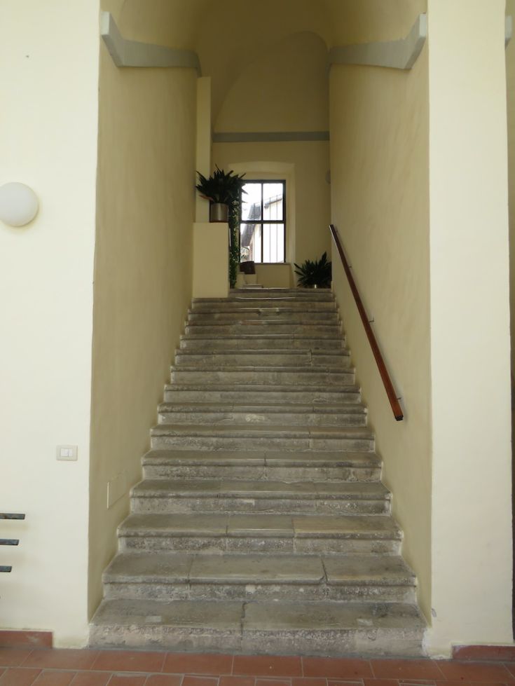 A staircase in a building leading to a bright apartment in the center of Spoleto.
