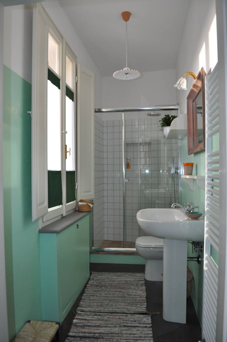 Bright modern bathroom with contemporary flooring, shower, and simple functional furnishings.