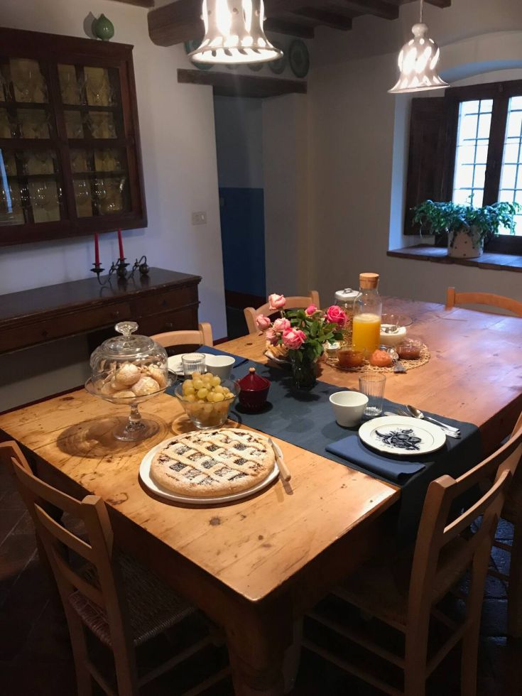 A beautifully set table with pastries, fruits, and drinks in a cozy dining room.