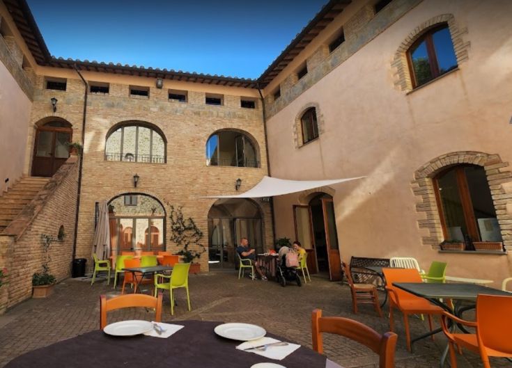 La corte interna di Torrenova ad Assisi è un ambiente tranquillo, perfetto per il relax e il buon cibo.