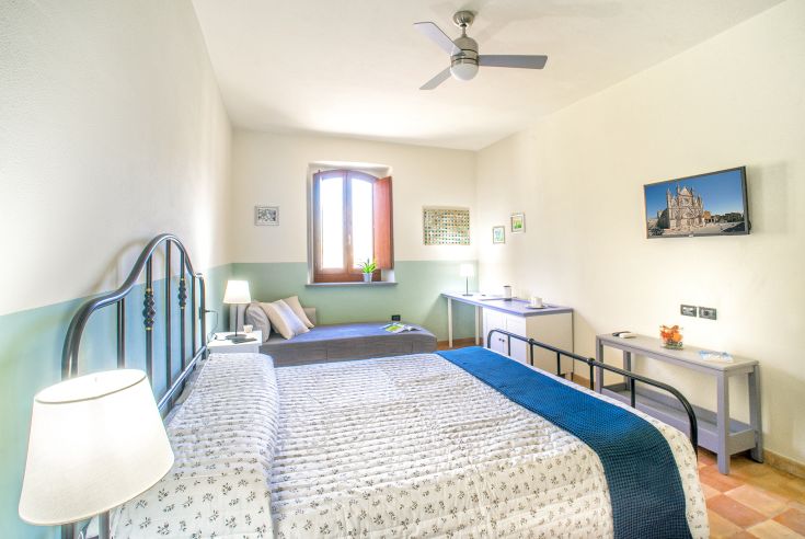 Camera accogliente e ben illuminata, che si affaccia sul parco e presenta arredi semplici.