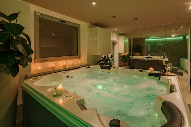 Un'area di benessere con una vasca idromassaggio e candele, perfetta per momenti di rilassamento.