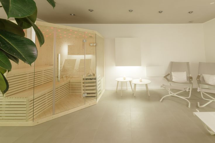 Un'area dedicata al relax e al benessere, caratterizzata da una sauna in un ambiente luminoso e contemporaneo.