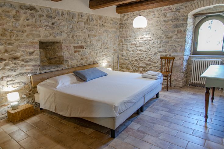 Cozy room with stone walls and simple decor, perfect for a peaceful stay.