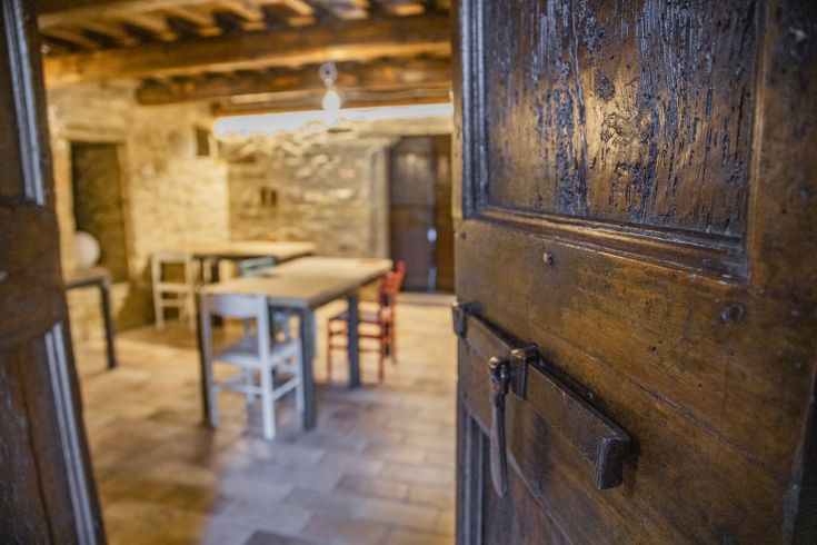 A comfortable agriturismo setting with wooden tables and chairs, featuring a warm and rustic atmosphere.