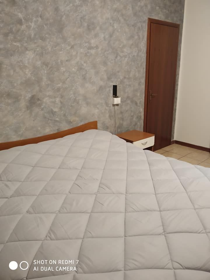 Camera matrimoniale con un grande letto e una parete decorativa, ideale per momenti di tranquillità.