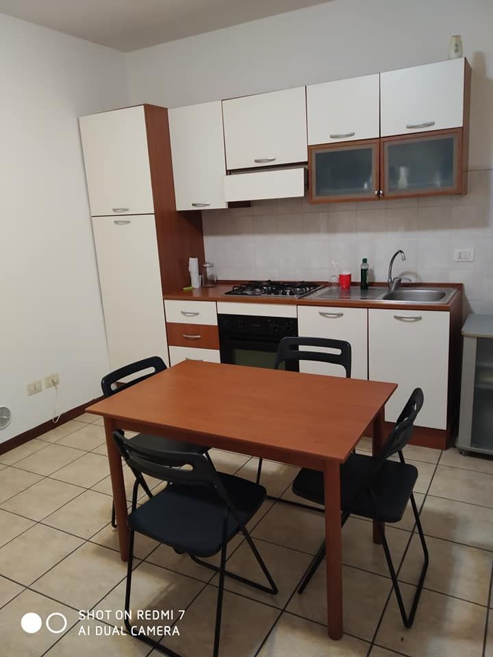 Cucina pratica e funzionale con tavolo e sedie, ottima per pasti in gruppo.