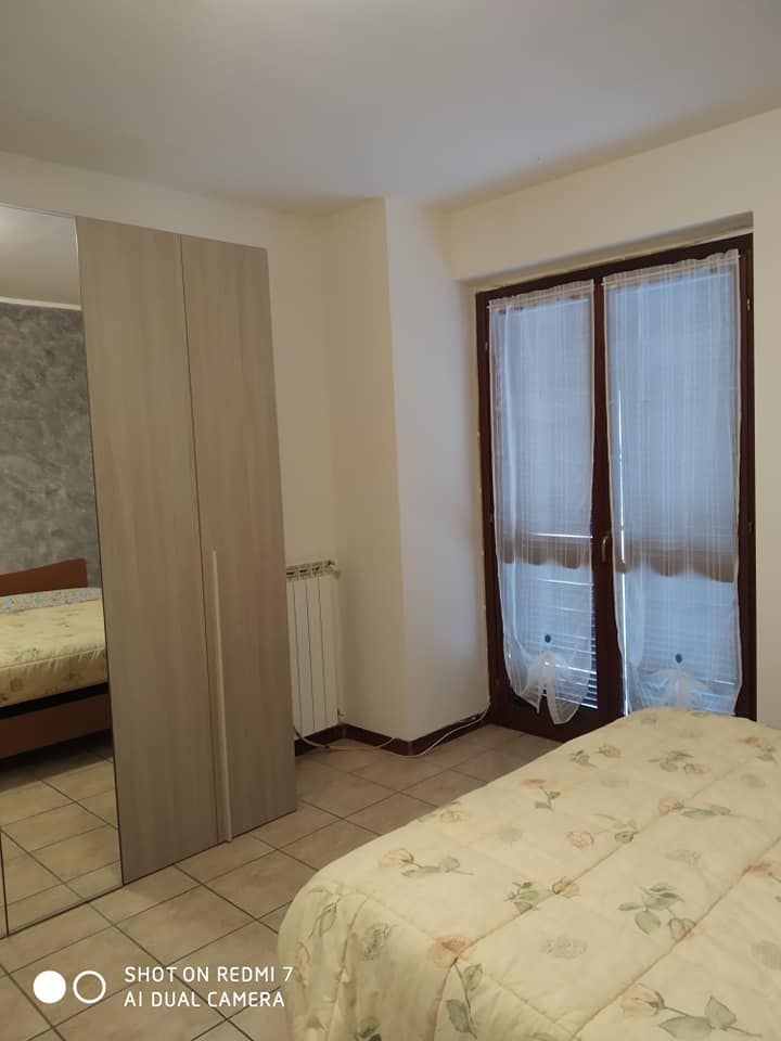 Camera semplice con armadio e finestre che lasciano filtrare la luce, perfetta per il riposo.