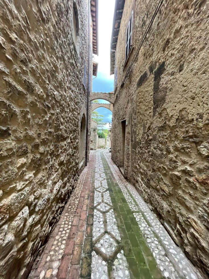 Un angolo caratteristico, con una via in pietra che si snoda tra alte mura storiche.