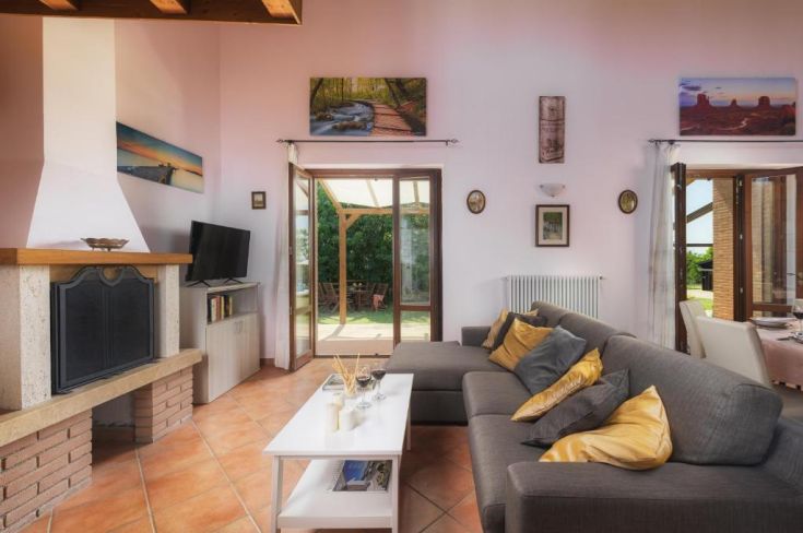 Ein ruhiges Wohnzimmer mit Kamin und direktem Zugang zum Garten, ideal zum Entspannen.