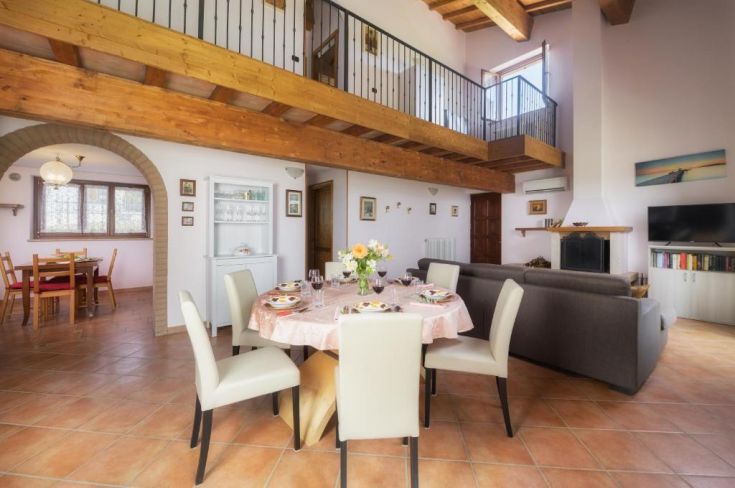 Geräumiges Wohnzimmer mit Esszimmertisch, Kamin und kompletter Küche. Ideal für Entspannung und gesellige Zusammenkünfte.