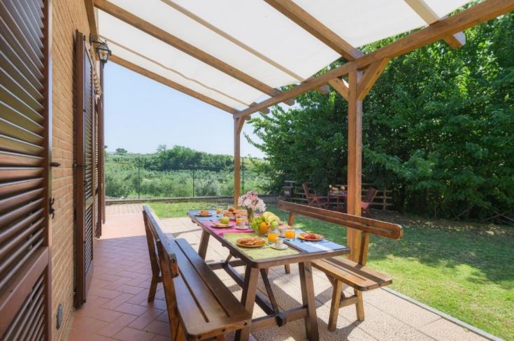 Essbereich im Freien mit Tisch, umgeben von Grün und Ruhe.