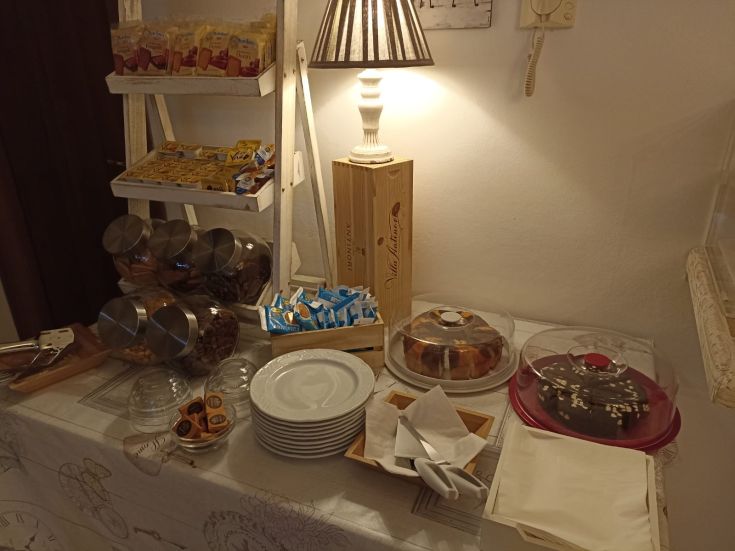 Colazione con un assortimento di dolci, biscotti e caffè in un ambiente caldo e accogliente.
