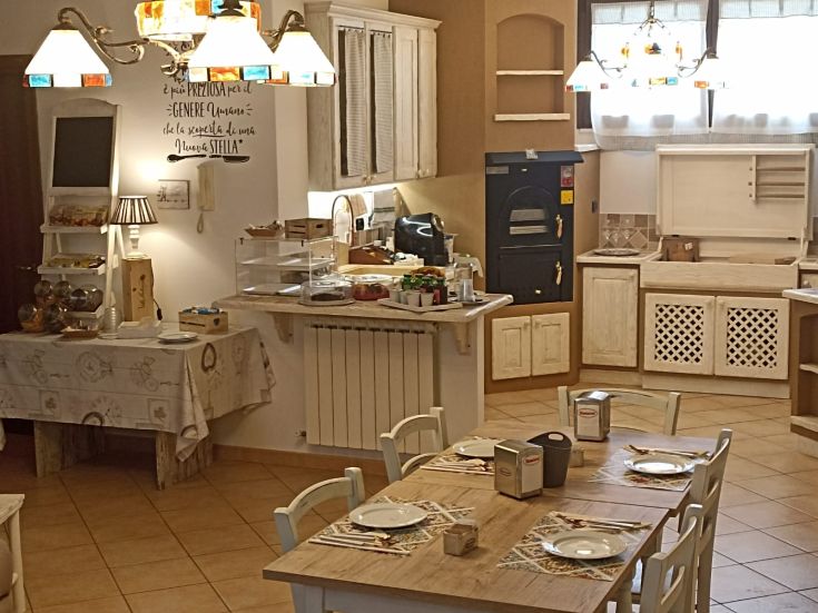 Ambiente confortevole e ben illuminato di un B&B, con tavoli apparecchiati per gli ospiti.