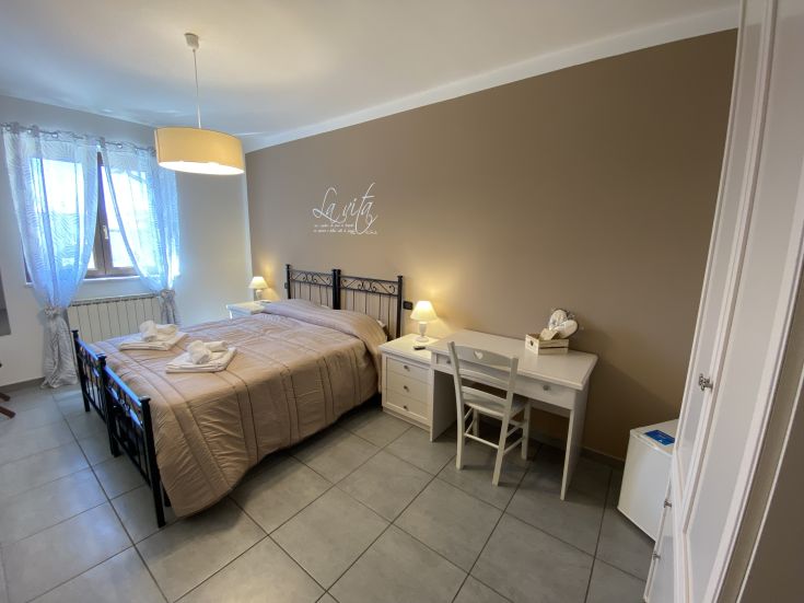 Spazio semplice e confortevole con letti matrimoniali e dettagli decorativi discreti.