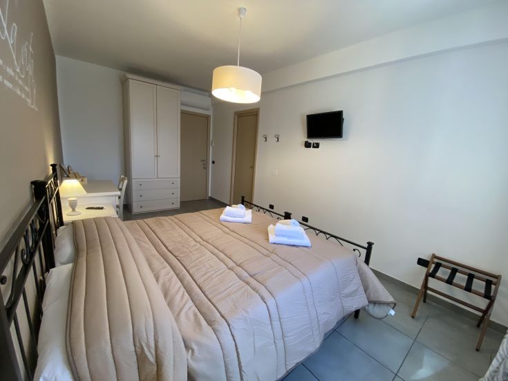 Camera matrimoniale semplice con mobili pratici e comfort necessari per un soggiorno tranquillo.