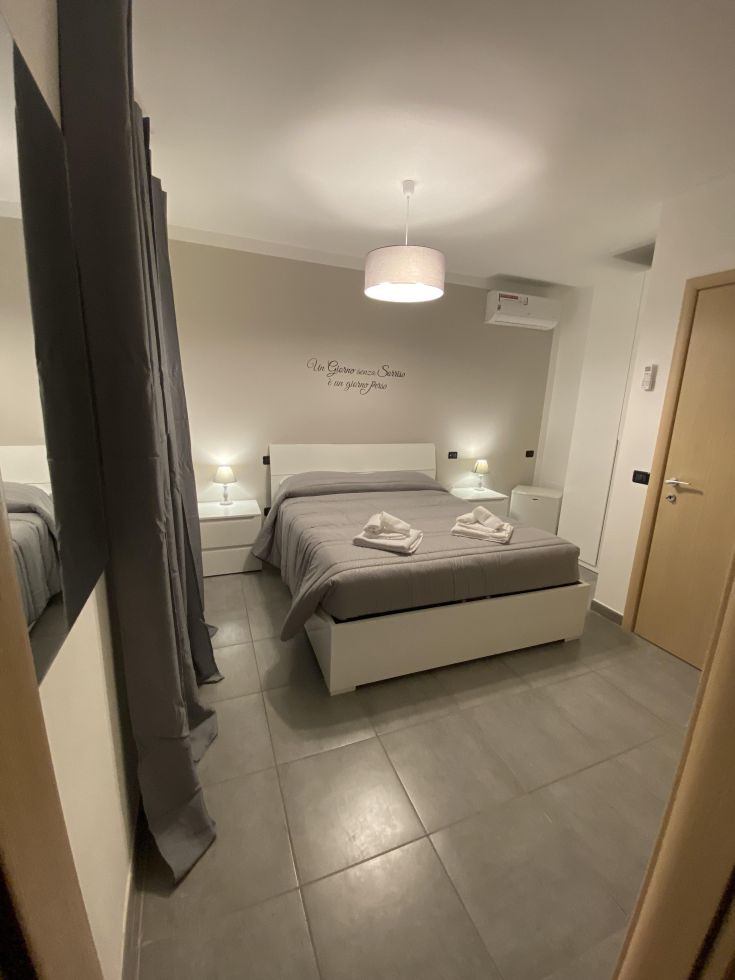 Spazio semplice con letto matrimoniale, arredato in modo pratico e moderno.