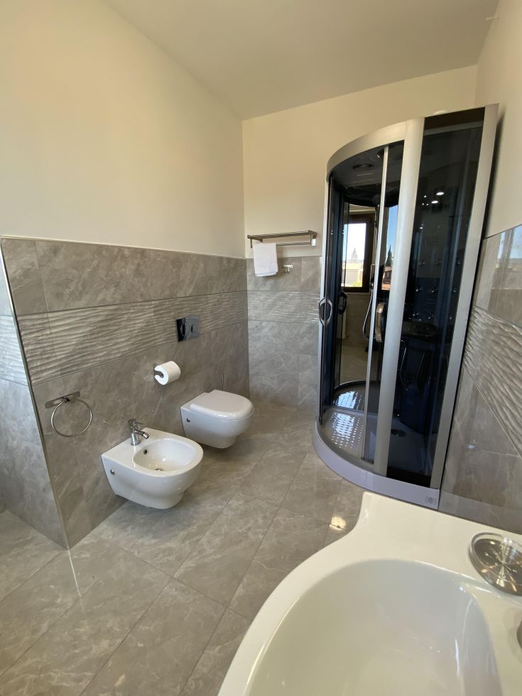 Un bagno con doccia e finiture in marmo, creando un ambiente accogliente per il relax.