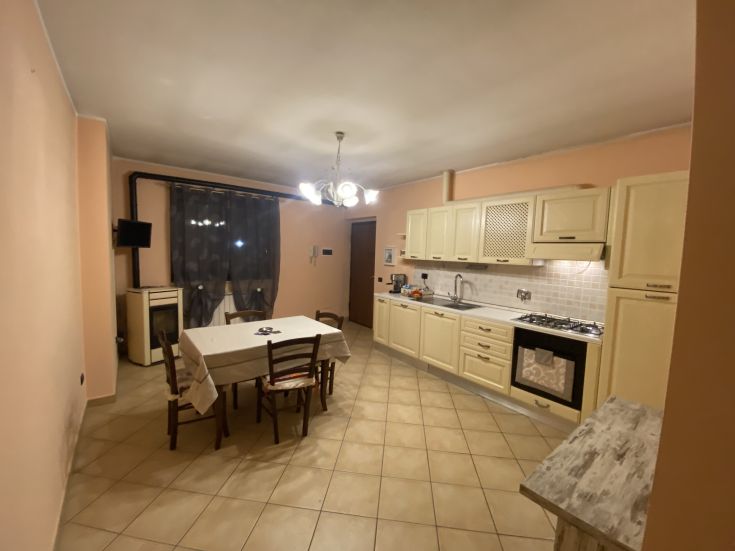 Una cucina ampia e funzionale, dotata di un tavolo e di attrezzature moderne per la preparazione dei pasti.