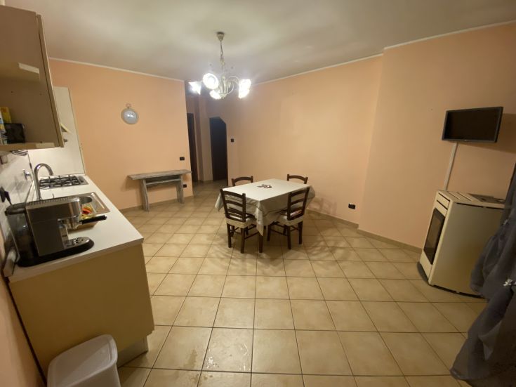 Spazioso soggiorno con tavolo e angolo cottura, adatto per trascorrere piacevoli momenti insieme.