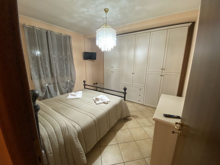 Camera semplice e confortevole con letti matrimoniali e armadi, adatta per momenti di tranquillità.