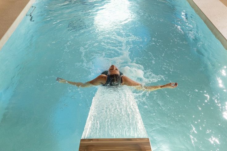 Una persona si rilassa in una piscina, immersa in un'atmosfera tranquilla e serena.