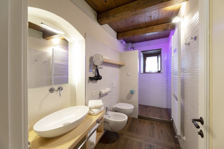 Un bagno dal design contemporaneo che combina elementi moderni e dettagli classici con tonalità chiare e legno. Ideale per momenti di relax.