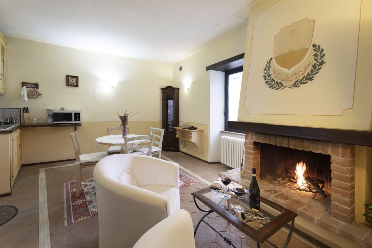 Un'area giorno comoda con camino e cucina funzionale, ideale per momenti di relax.