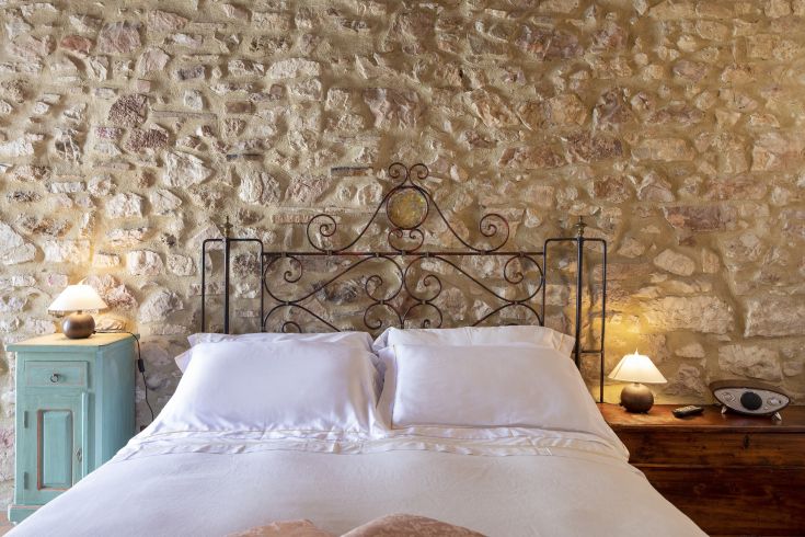 Camera confortevole con pareti in pietra e mobili semplici, adatta per un soggiorno tranquillo.