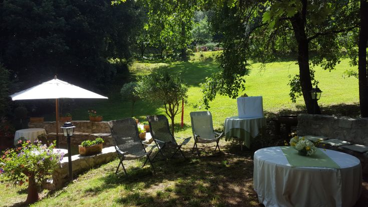 An outdoor garden with tables, sunbeds, and plants, perfect for relaxation moments.