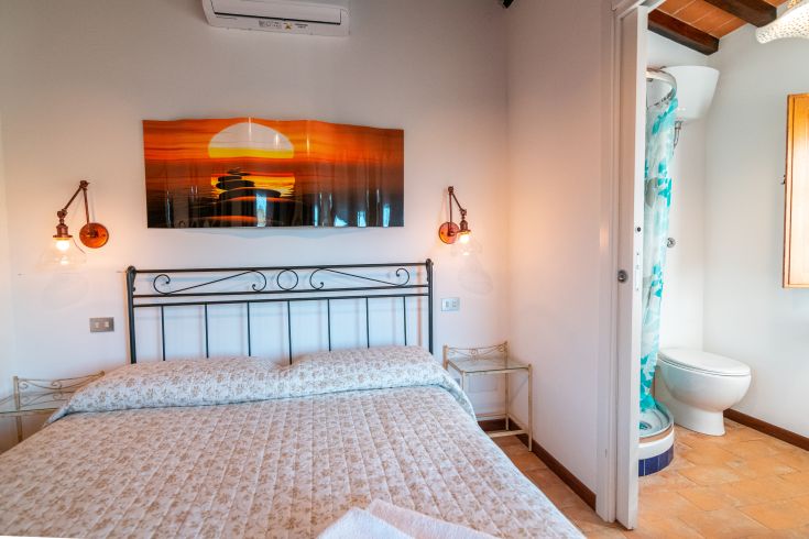 Gut eingerichtetes Schlafzimmer mit Doppelbett und einfachen Dekorationen.