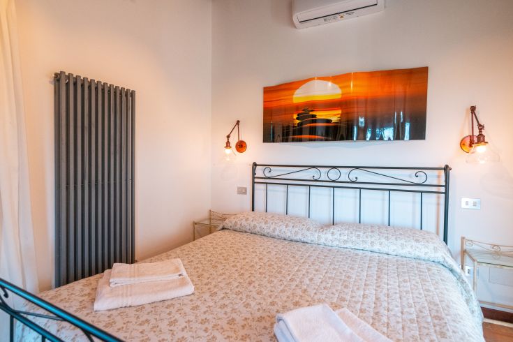 Geräumiges Zimmer mit einem Doppelbett und einfachen Wanddekorationen.