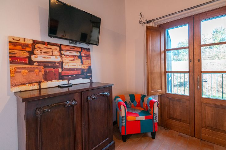 Ecke eines Bauernhauses mit einem bunten Sessel und Blick auf die umliegende Landschaft.