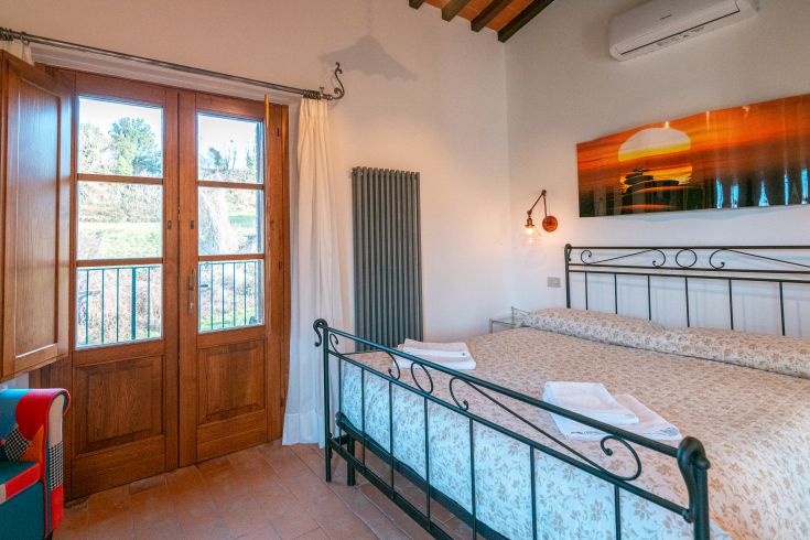 Zimmer in einem umbrischen Bauernhaus, einfach und gut organisiert, mit Blick auf die umliegende Landschaft.