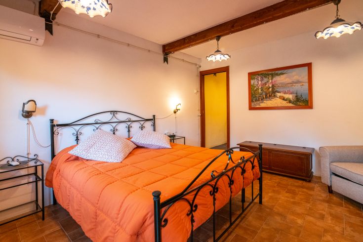 Ein einfaches und komfortables Zimmer mit einem Doppelbett und schlichter Dekoration. Perfekt für Entspannung.