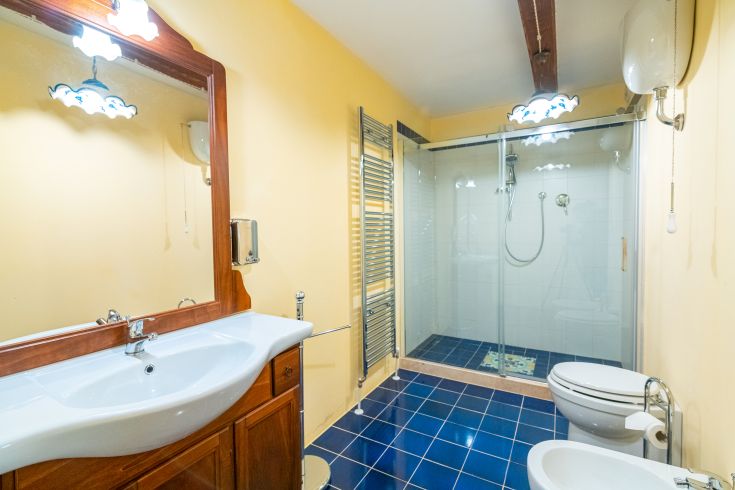 Helles modernes Bad mit Dusche, Spiegel und schlichten Oberflächen.