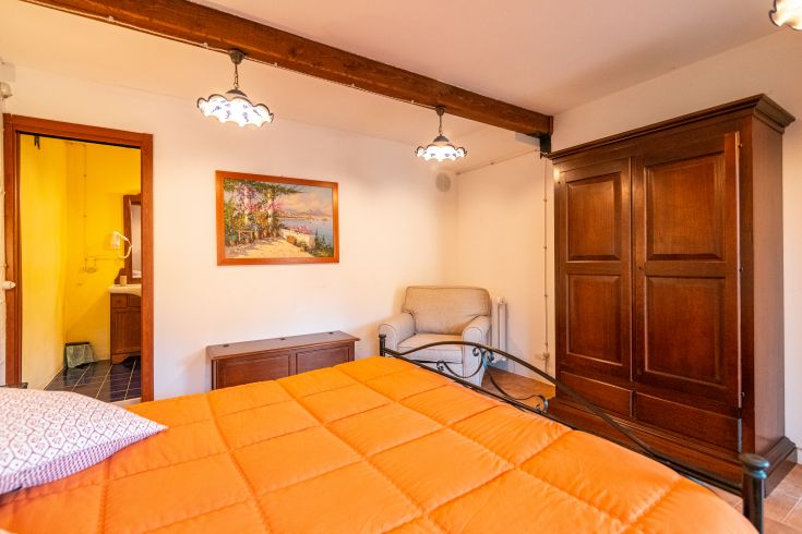 Gemütliches Zimmer mit einem Doppelbett und einfacher, rustikaler Einrichtung.