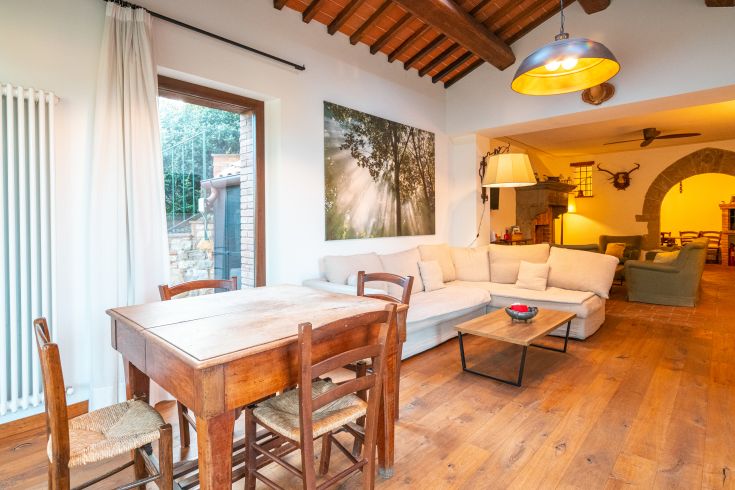 Ein gemütlicher Wohnbereich im rustikalen Stil, mit warmem Licht und Bereichen zum Entspannen und Geselligkeit.