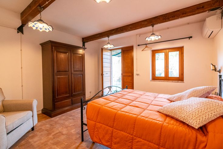 Ein einfaches Zimmer mit einem Doppelbett, ausgestattet mit rustikalen Möbeln und einer warmen Atmosphäre.