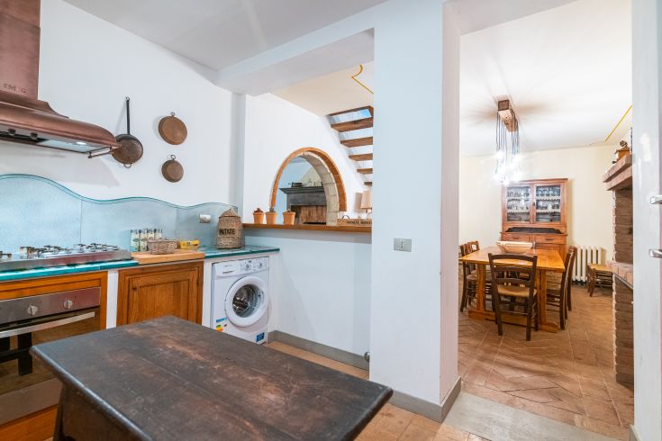 Gemütliche Küche mit einem gut organisierten Tisch, Herd und Waschbereich.