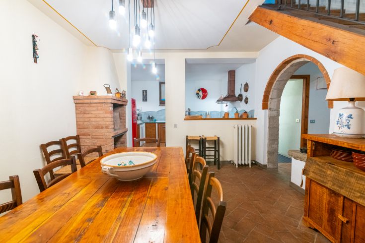 Geräumige Küche mit einem zentralen Holztisch, ideal für Versammlungen und Abendessen.