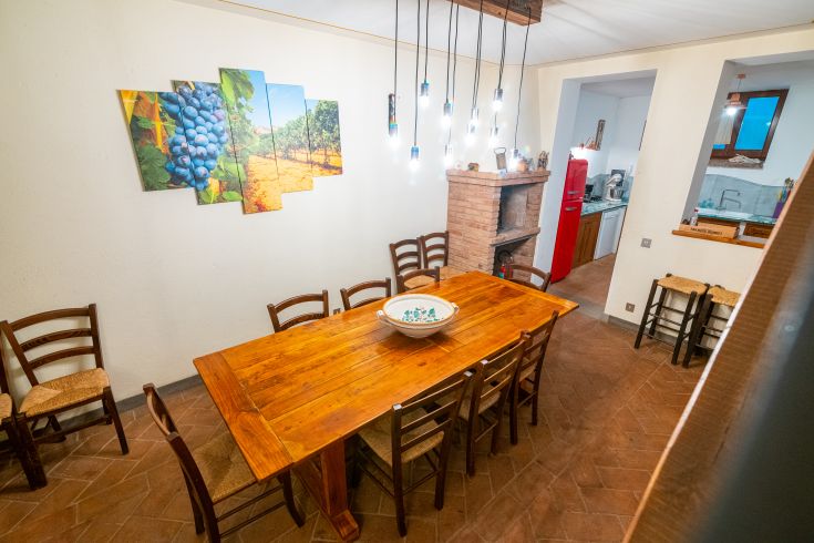 Gut eingerichteter Essbereich in einem Bauernhaus mit einem Holztisch und einfachen, natur inspirierten Dekorationen.