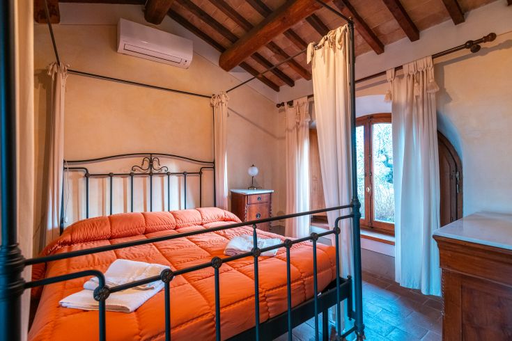 Gemütliches rustikales Zimmer mit Schmiedeeisenbetten und einfachen Details.